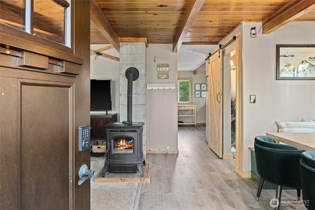 7 Moonshine Ln, Ronald, WA 98940 - living area with a barn door, wood finished floors, a wooden ceiling with exposed beams, and a wood stove