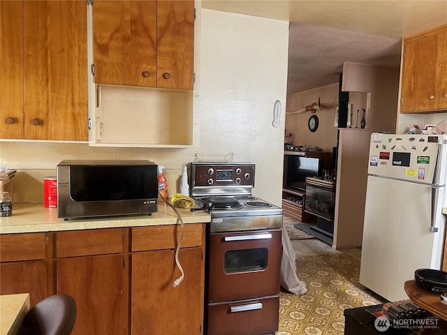 5006 N 28th, Tacoma, WA 98407 - kitchen featuring freestanding refrigerator, range with electric cooktop, light countertops, and brown cabinets