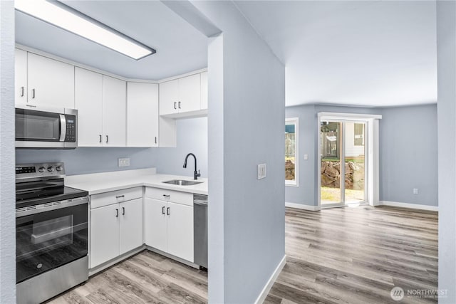 12608 NE 119th St Unit B8, Kirkland, WA 98034 - kitchen with stainless steel appliances, light wood-style floors, light countertops, and white cabinets