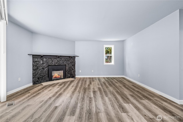 12608 NE 119th St Unit B8, Kirkland, WA 98034 - unfurnished living room featuring wood finished floors and a stone fireplace