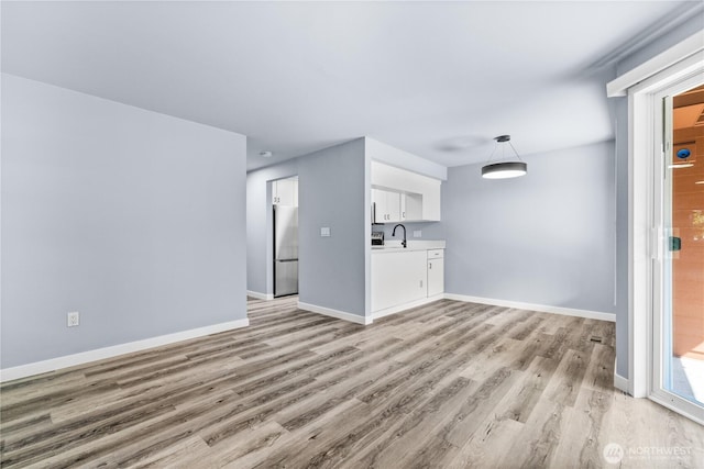 12608 NE 119th St Unit B8, Kirkland, WA 98034 - unfurnished living room featuring light wood-type flooring and baseboards