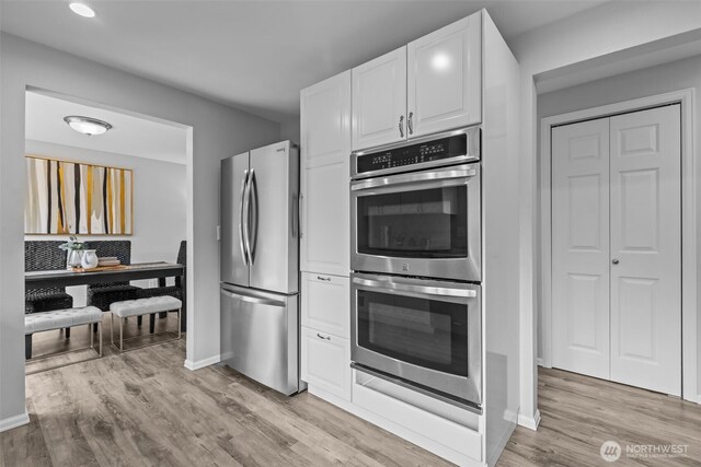 13002 145th St E, Puyallup, WA 98374 - kitchen with appliances with stainless steel finishes, white cabinetry, and light wood-style flooring