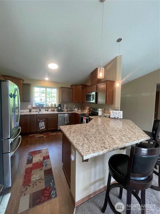 1717 Krause Rd, Raymond, WA 98577 - kitchen featuring stainless steel appliances, a peninsula, vaulted ceiling, a kitchen bar, and light stone countertops