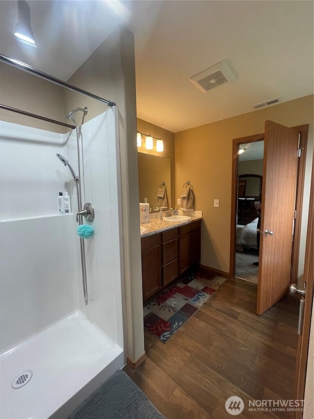 1717 Krause Rd, Raymond, WA 98577 - full bathroom featuring wood finished floors, ensuite bath, a walk in shower, and double vanity