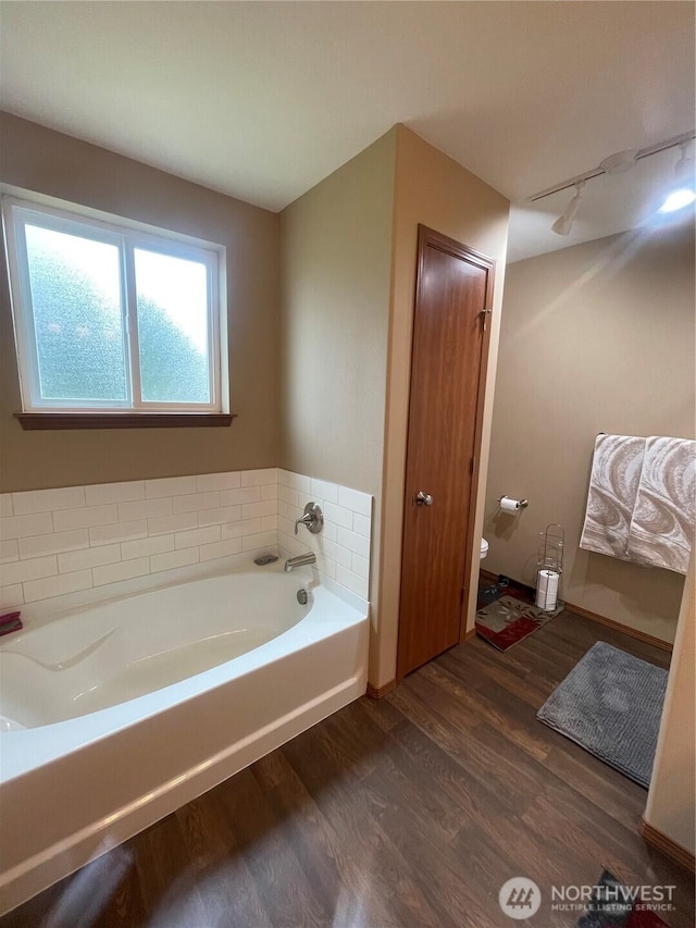 1717 Krause Rd, Raymond, WA 98577 - bathroom featuring wood finished floors, a bath, and track lighting