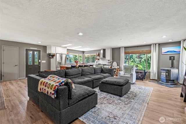 106 Barba Rd, Castle Rock, WA 98611 - living room featuring a wood stove, a textured ceiling, light wood-style floors, and recessed lighting