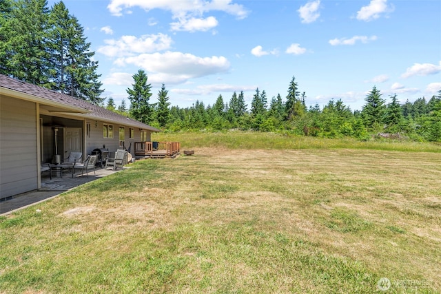 106 Barba Rd, Castle Rock, WA 98611 - view of green lawn featuring a wooden deck and a patio area