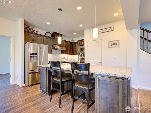 1706 NW 17th St, Battle Ground, WA 98604 - kitchen featuring stainless steel appliances, dark brown cabinetry, recessed lighting, a center island with sink, and light wood-style floors