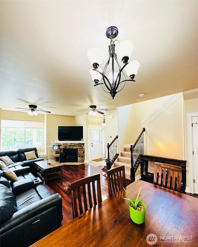 27120 105th Pl SE, Kent, WA 98030 - dining space with a ceiling fan, stairway, a chandelier, wood finished floors, and a stone fireplace