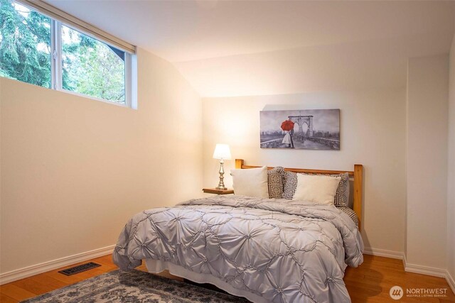 10761 Bill Point Crst NE, Bainbridge Island, WA 98110 - bedroom featuring wood finished floors and vaulted ceiling