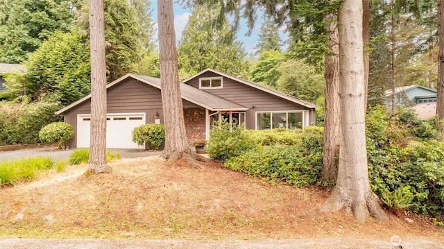 10761 Bill Point Crst NE, Bainbridge Island, WA 98110 - view of front of property featuring driveway, an attached garage, and brick siding