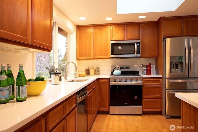 10761 Bill Point Crst NE, Bainbridge Island, WA 98110 - kitchen featuring stainless steel appliances, light countertops, light wood-style floors, recessed lighting, and brown cabinets