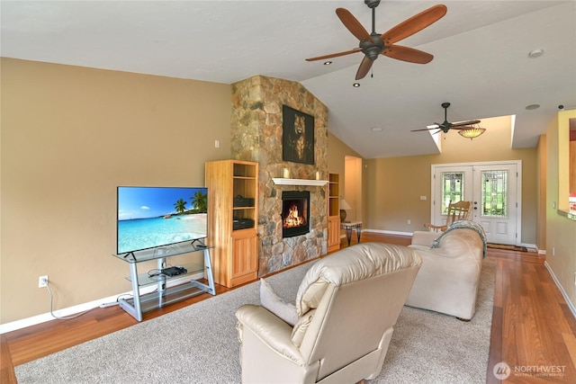 2360 Sapp Rd SW, Tumwater, WA 98512 - living area with wood finished floors, a ceiling fan, vaulted ceiling, a fireplace, and french doors