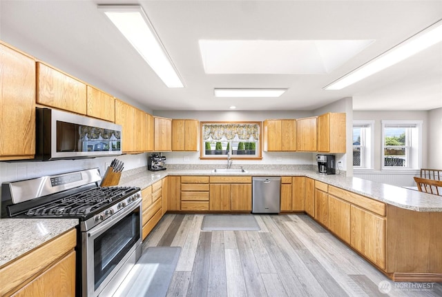824 Orth Way, Sedro Woolley, WA 98284 - kitchen featuring stainless steel appliances, a peninsula, light wood finished floors, and light stone counters