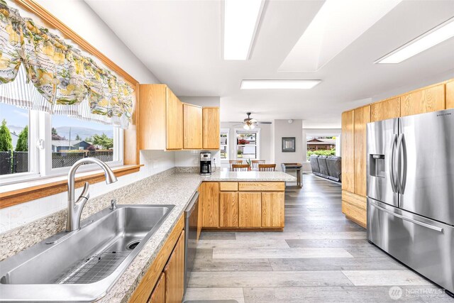 824 Orth Way, Sedro Woolley, WA 98284 - kitchen with appliances with stainless steel finishes, a peninsula, light wood finished floors, light countertops, and a ceiling fan
