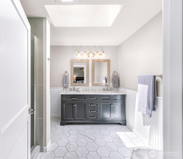 824 Orth Way, Sedro Woolley, WA 98284 - full bath with wainscoting, a skylight, double vanity, tile patterned flooring, and an enclosed shower