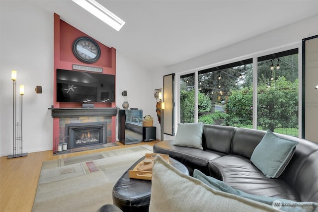 2212 186th Ave NE, Redmond, WA 98052 - living room featuring a tiled fireplace, wood finished floors, high vaulted ceiling, and a skylight