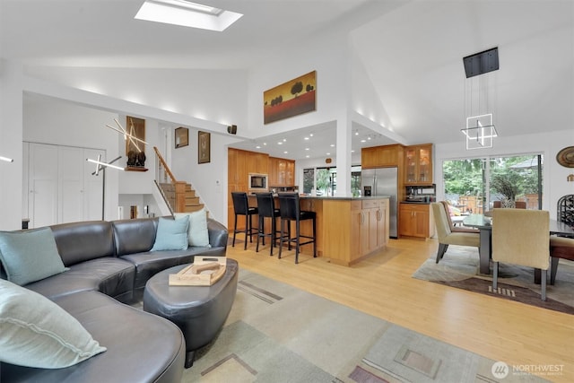 2212 186th Ave NE, Redmond, WA 98052 - living area with light wood-style flooring, stairway, a chandelier, a skylight, and high vaulted ceiling