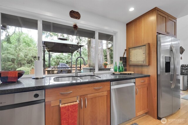 2212 186th Ave NE, Redmond, WA 98052 - kitchen with appliances with stainless steel finishes, dark stone countertops, brown cabinets, light wood-style floors, and recessed lighting