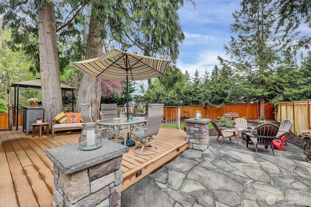 2212 186th Ave NE, Redmond, WA 98052 - wooden deck featuring a gazebo, a fire pit, a fenced backyard, outdoor dining space, and a patio