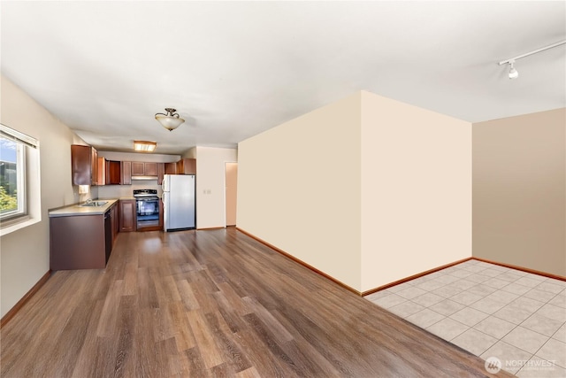 6117 39th Dr NW, Marysville, WA 98271 - kitchen with freestanding refrigerator, range with electric stovetop, light countertops, under cabinet range hood, and light wood-style flooring