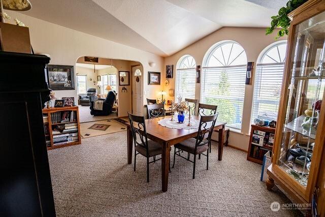 1448 Rd C NE, Moses Lake, WA 98837 - dining space with carpet flooring, vaulted ceiling, and arched walkways