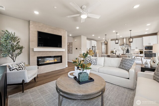 20259 145th St E Unit 856, Bonney Lake, WA 98391 - living area with light wood-style floors, a ceiling fan, a fireplace, and recessed lighting