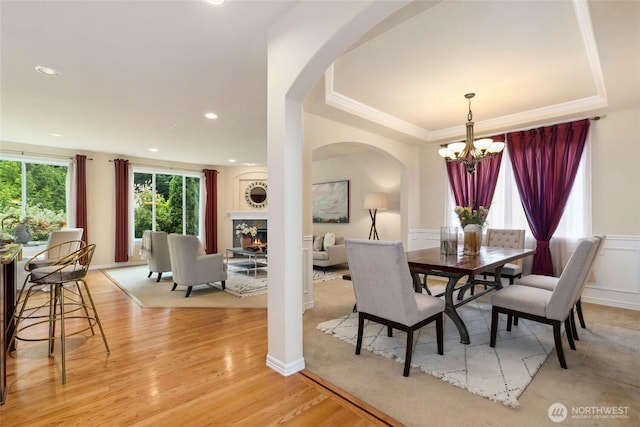 24826 SE 22nd Ct, Sammamish, WA 98075 - dining area featuring a chandelier, arched walkways, light wood-style flooring, a tray ceiling, and recessed lighting