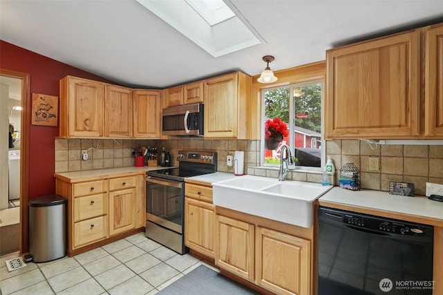 6338 Kirsop, Olympia, WA 98512 - kitchen featuring appliances with stainless steel finishes, a skylight, vaulted ceiling, backsplash, and light countertops