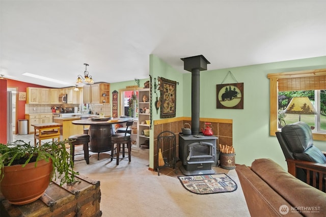 6338 Kirsop, Olympia, WA 98512 - living room featuring a wood stove, a chandelier, and light carpet