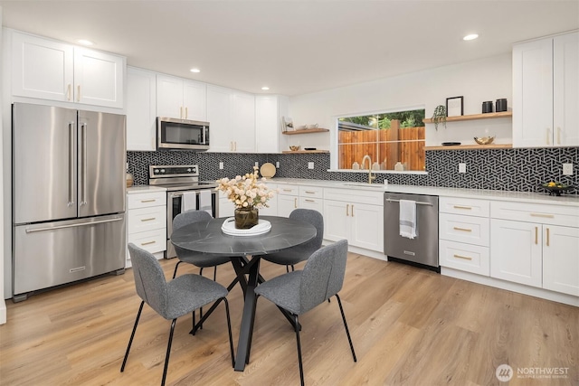 9224 36th Ave SW Unit 2, Seattle, WA 98126 - kitchen featuring appliances with stainless steel finishes, open shelves, light wood finished floors, white cabinets, and recessed lighting