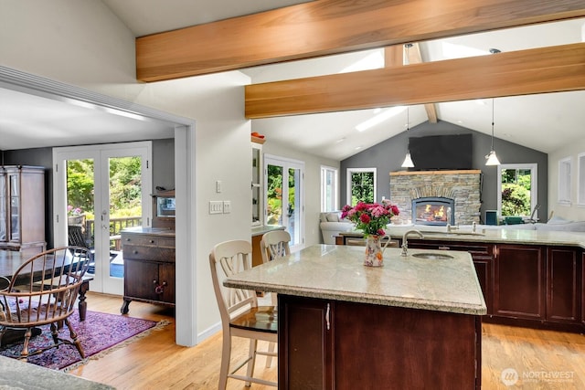 16525 39th Ave NE, Lake Forest Park, WA 98155 - kitchen with french doors, open floor plan, light wood finished floors, a stone fireplace, and light stone counters