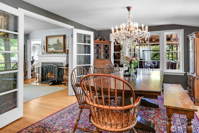 16525 39th Ave NE, Lake Forest Park, WA 98155 - dining area with a chandelier, wood finished floors, healthy amount of natural light, a brick fireplace, and lofted ceiling