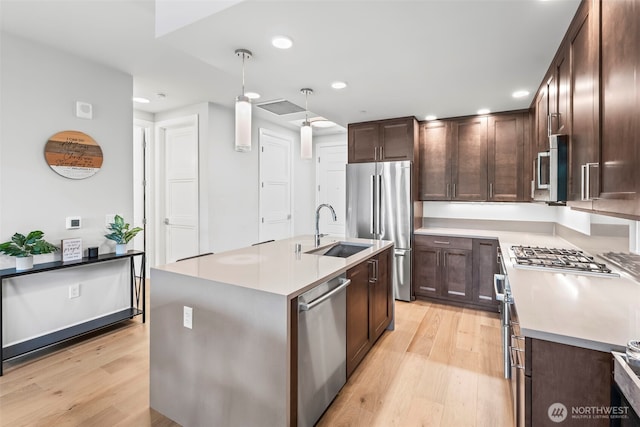 4907 Main St Unit 830, Tacoma, WA 98407 - kitchen featuring appliances with stainless steel finishes, light wood-style flooring, dark brown cabinets, and recessed lighting