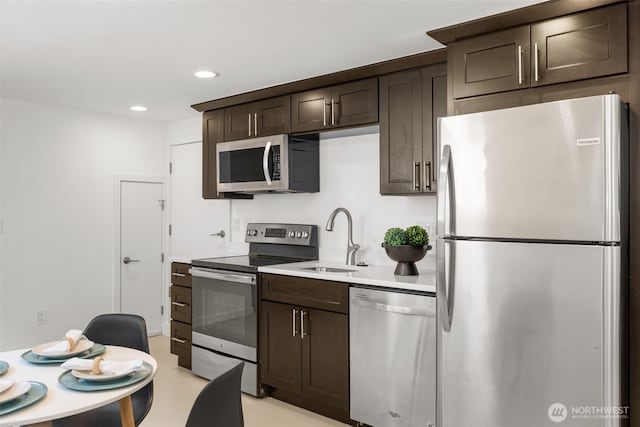 6427 Flora Ave S, Seattle, WA 98108 - kitchen featuring appliances with stainless steel finishes, dark brown cabinets, light countertops, and recessed lighting