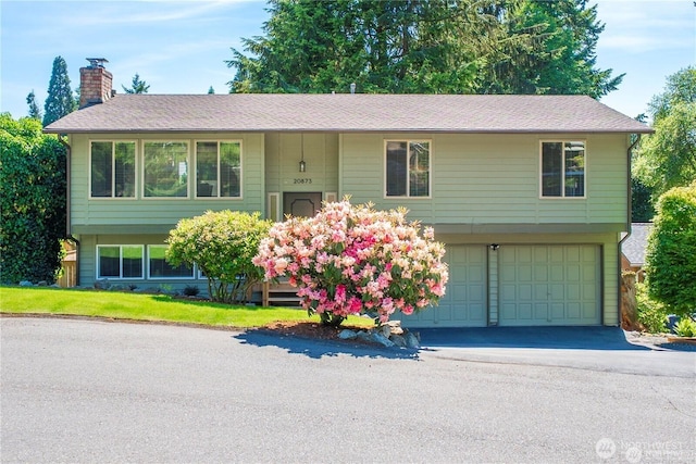 20873 2nd Pl SW, Normandy Park, WA 98166 - bi-level home featuring a chimney, an attached garage, driveway, and a shingled roof