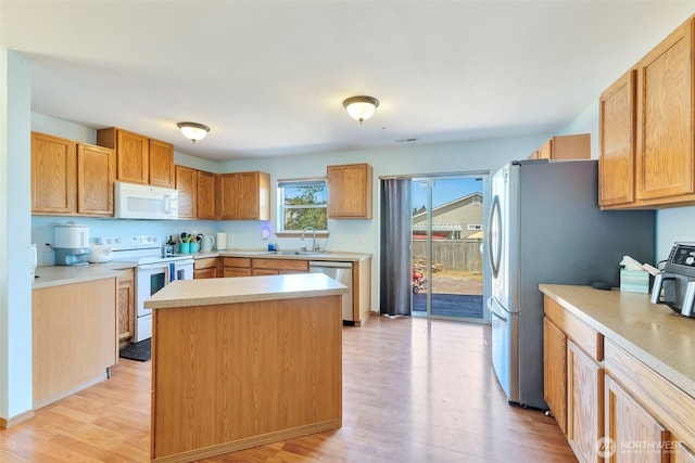 109 Nelsen St NE, Orting, WA 98360 - kitchen featuring stainless steel appliances, light wood-type flooring, light countertops, and a kitchen island