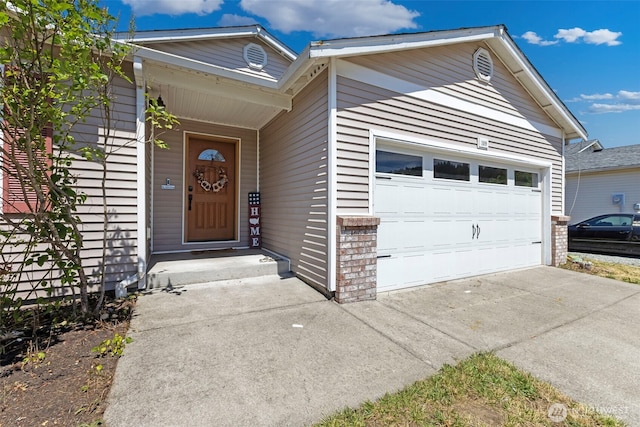 109 Nelsen St NE, Orting, WA 98360 - view of exterior entry with an attached garage and driveway