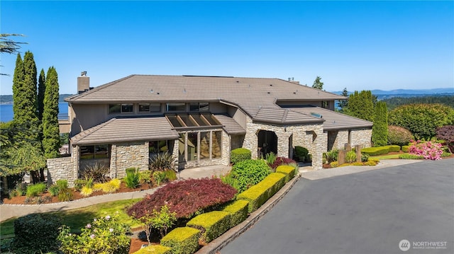 6411 View St NE, Tacoma, WA 98422 - view of front of house with stone siding, a chimney, a tile roof, and stucco siding