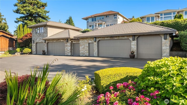 6411 View St NE, Tacoma, WA 98422 - view of front of property featuring stone siding, a garage, and a tiled roof