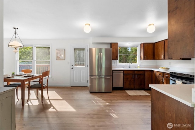 4530 Vacca Ln, Bellingham, WA 98226 - kitchen with stainless steel appliances, light countertops, light wood-style flooring, and pendant lighting