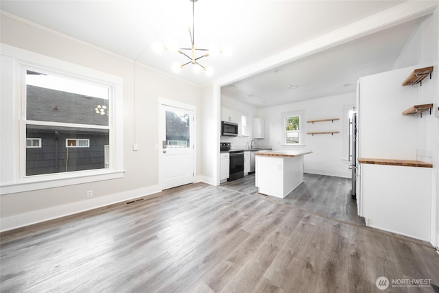 6753 14th Ave NW, Seattle, WA 98117 - kitchen featuring wood counters, stainless steel appliances, open shelves, white cabinetry, and ornamental molding