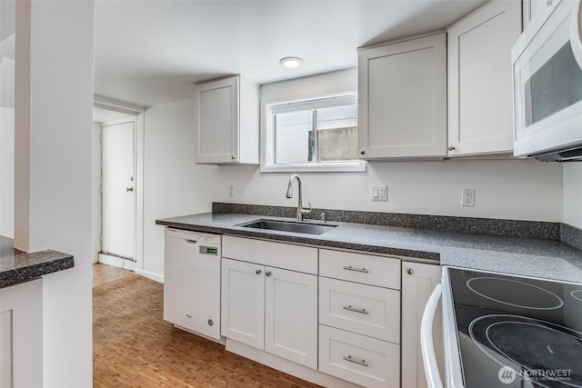 6753 14th Ave NW, Seattle, WA 98117 - kitchen with white appliances, dark countertops, light wood-style flooring, and white cabinetry