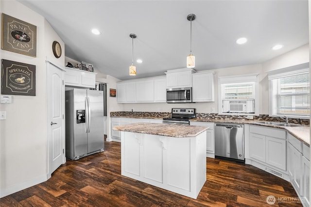 120 L St SE, Auburn, WA 98002 - kitchen featuring appliances with stainless steel finishes, a center island, dark wood-style floors, light stone counters, and white cabinets