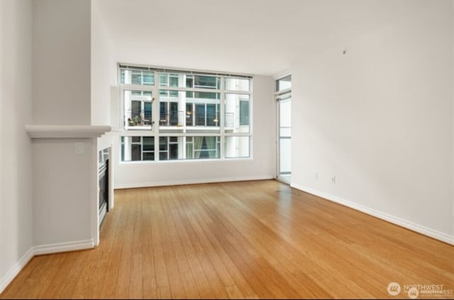 1420 Terry Ave Unit 907, Seattle, WA 98101 - unfurnished living room with wood finished floors and a fireplace