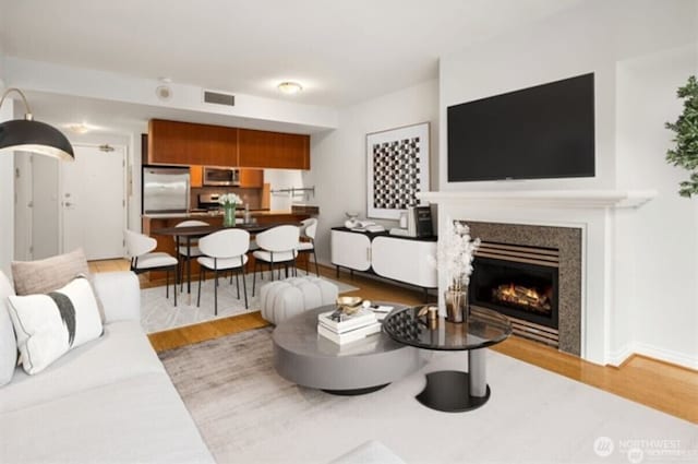 1420 Terry Ave Unit 907, Seattle, WA 98101 - living area featuring wood finished floors and a glass covered fireplace