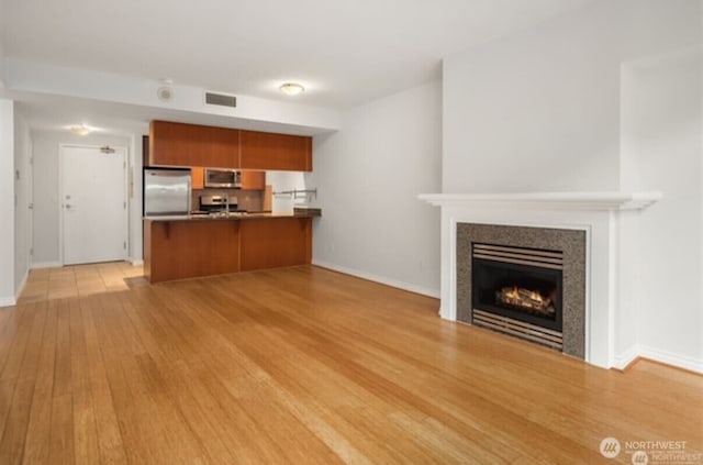 1420 Terry Ave Unit 907, Seattle, WA 98101 - unfurnished living room featuring a tiled fireplace and light wood-style flooring