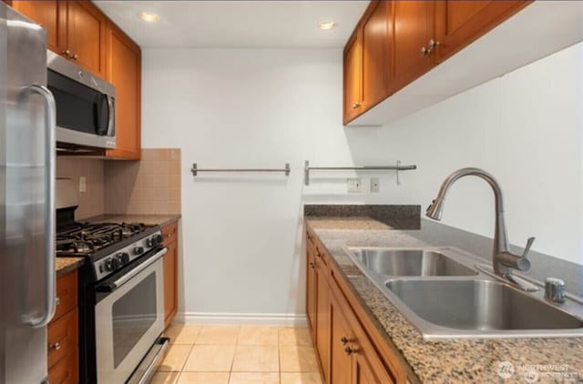1420 Terry Ave Unit 907, Seattle, WA 98101 - kitchen with stainless steel appliances, brown cabinetry, backsplash, recessed lighting, and light stone counters