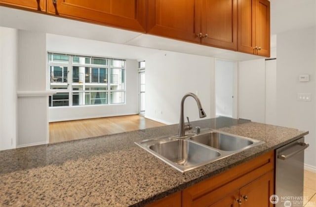 1420 Terry Ave Unit 907, Seattle, WA 98101 - kitchen featuring dishwasher, brown cabinetry, and dark stone countertops