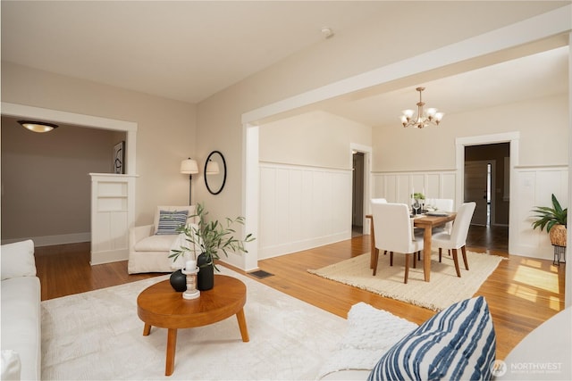 3207 N 9th St, Tacoma, WA 98406 - living area featuring a chandelier, a wainscoted wall, and wood finished floors